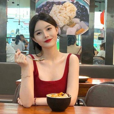 低胸红背心美女吃饭抓拍图片