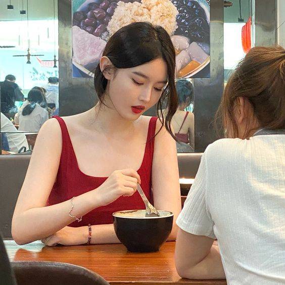 低胸红背心美女吃饭抓拍图片_2