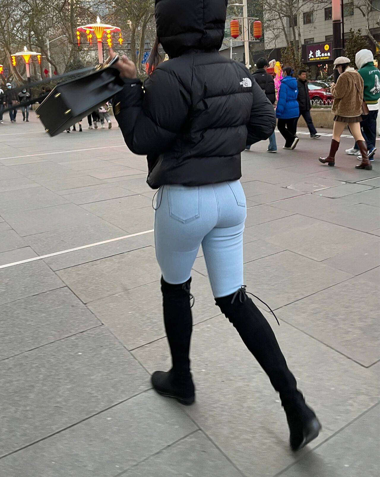 街拍穿搭北面羽绒服搭配牛仔裤的翘臀美女_3
