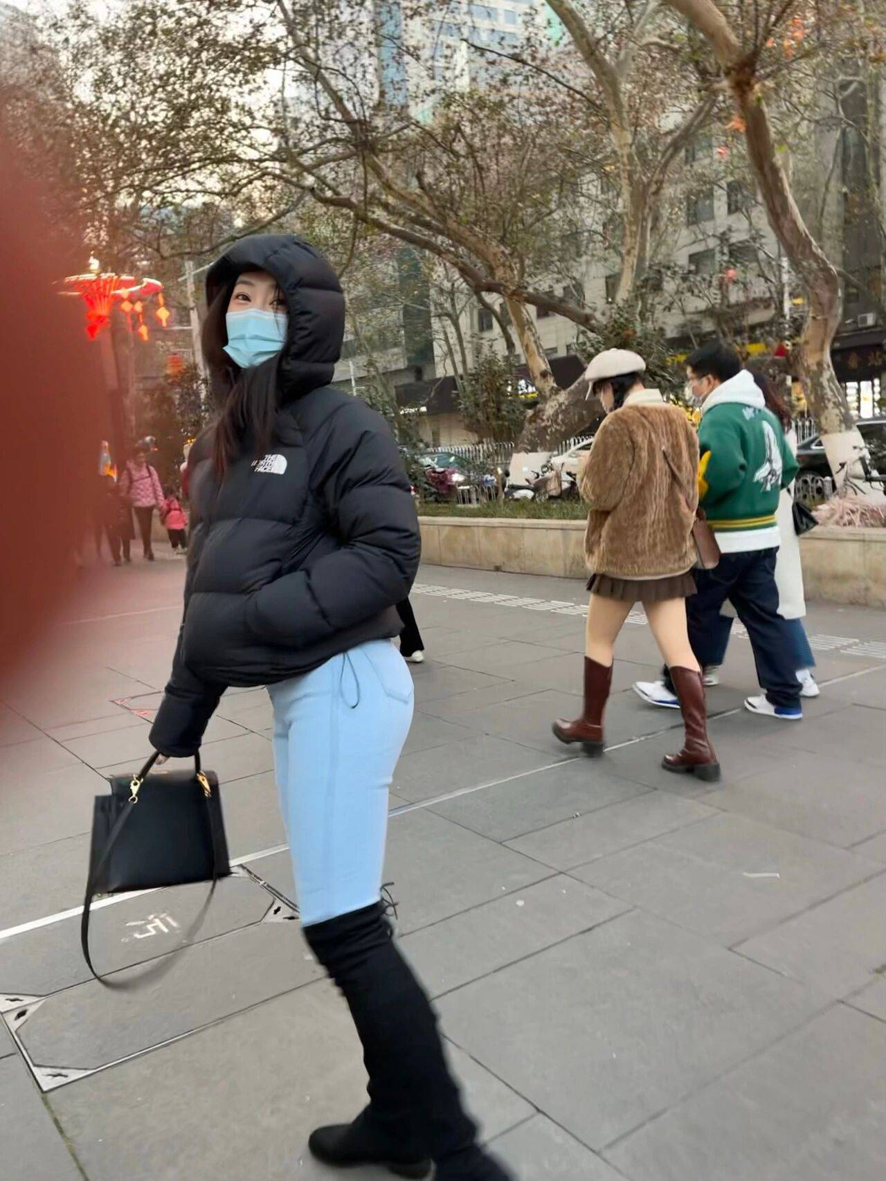 街拍穿搭北面羽绒服搭配牛仔裤的翘臀美女_2