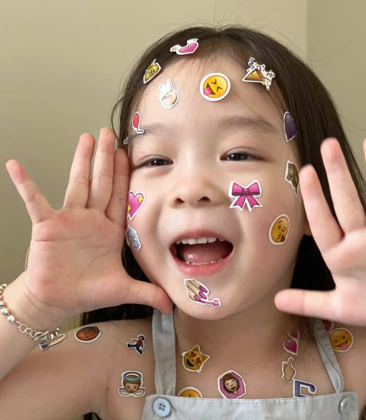 脸上胳膊上贴满emoji表情贴纸的可爱女孩头像 真实小女孩照片女生头像图_1