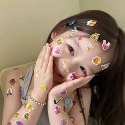 脸上胳膊上贴满emoji表情贴纸的可爱女孩头像 真实小女孩照片女生头像图