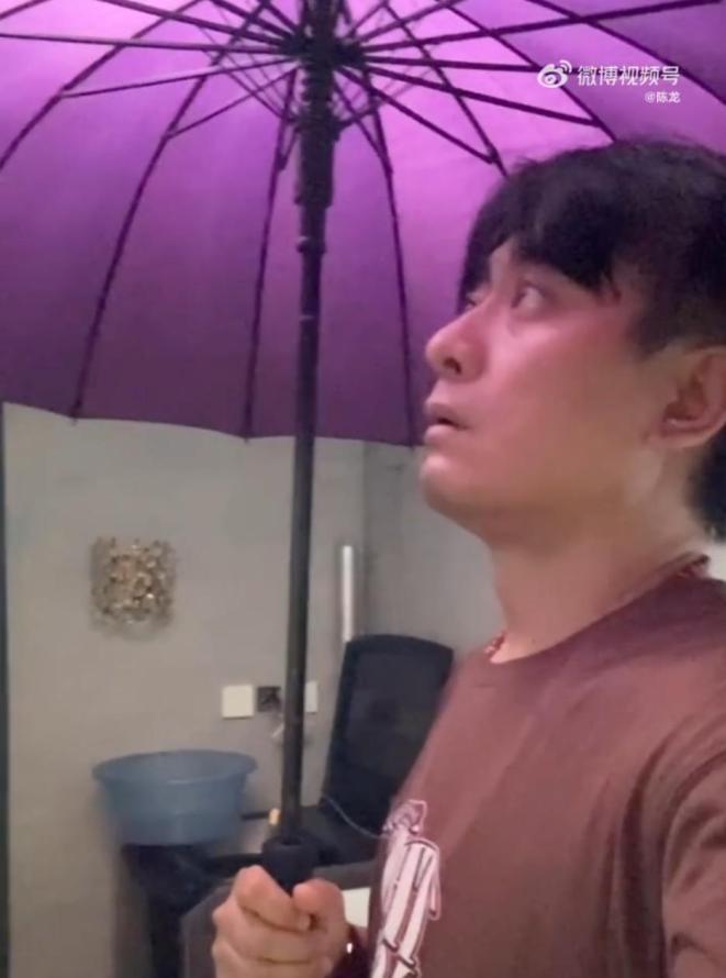 陈龙漏雨在家撑伞图片_2